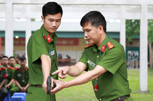 Trung tá Lê Quang Bá ân cần hướng dẫn học viên kĩ thuật ngắm bắn. Theo thầy Bá, môn bắn súng ngắn cũng góp phần rèn luyện tinh thần, ý chí, lòng quyết tâm, dũng cảm cho cán bộ, chiến sĩ.